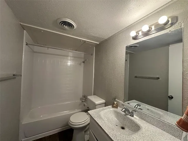 a bathroom with a sink a toilet a mirror and shower