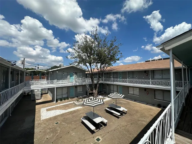 a view of a patio with couches table and chairs with wooden floor and fence