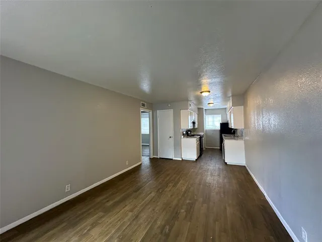 a view of a living room hardwood and kitchen with a sink
