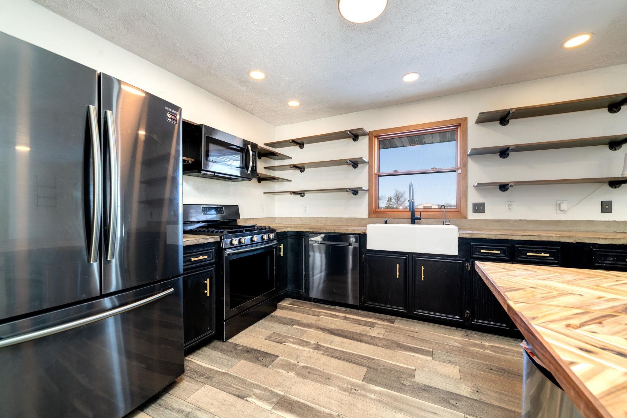 a kitchen with stainless steel appliances granite countertop a refrigerator a sink and a stove