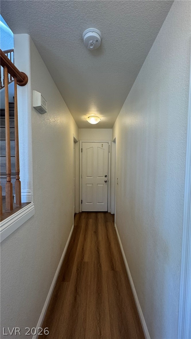 9716 Ridge Creek Place Las Vegas, NV 89134 - Photo 11 of 28 This inviting hallway features rich hardwood flooring and a classic door, leading to comfortable living spaces.