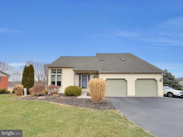 a view of a white house with a yard and plants