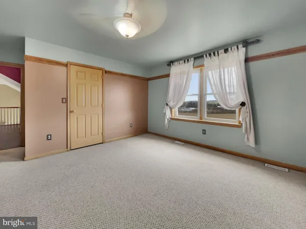 an empty room with a fireplace and windows