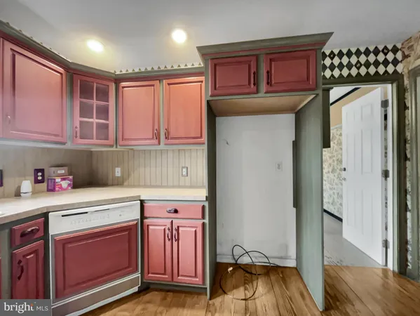 a kitchen with a refrigerator a oven and wooden cabinets