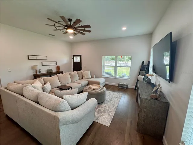 a kitchen with stainless steel appliances kitchen island granite countertop a table chairs sink and cabinets