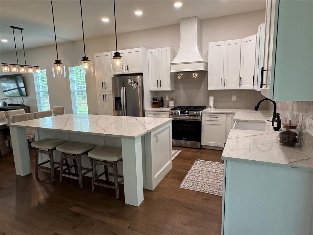4275 Beacon Light Road Edgewater, FL 32141 - Photo 20 of 48 a kitchen with stainless steel appliances kitchen island granite countertop a table chairs sink and cabinets
