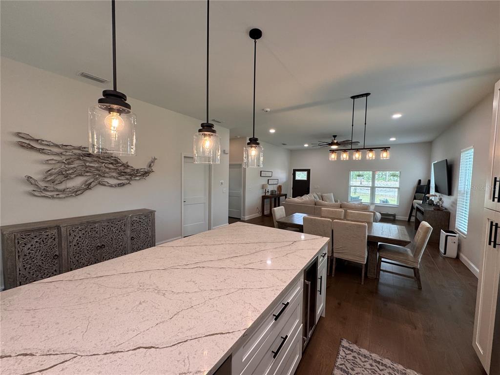 4275 Beacon Light Road Edgewater, FL 32141 - Photo 22 of 48 a large kitchen with kitchen island a stove a sink a center island a dining table and chairs