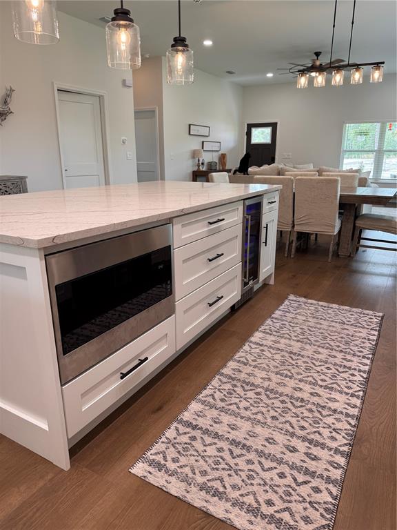 4275 Beacon Light Road Edgewater, FL 32141 - Photo 27 of 48 a kitchen with stainless steel appliances kitchen island granite countertop a stove top oven a sink a dining table and chairs with wooden floor
