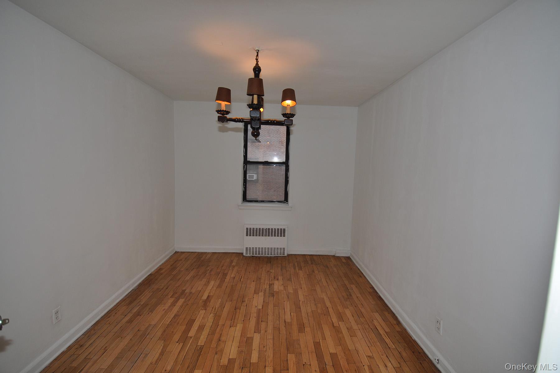 142 Garth Road, Unit 1R Scarsdale, NY 10583 - Photo 6 of 12 a view of a room with wooden floor and a ceiling fan