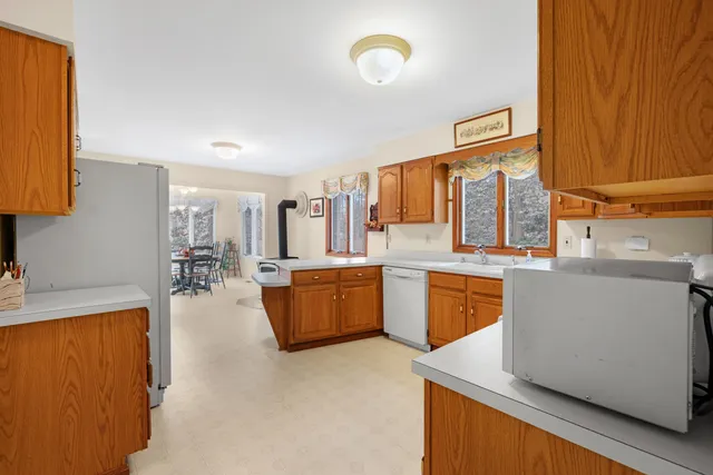 a large kitchen with lot of cabinets and wooden floor