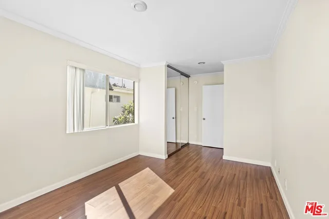 a view of a big room with wooden floor and windows
