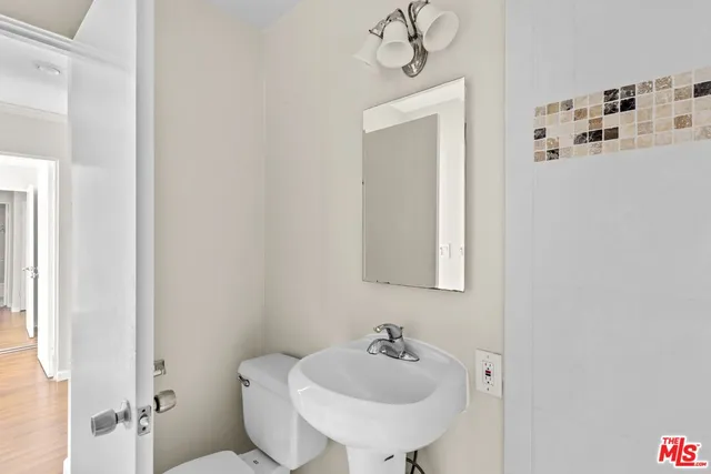 a bathroom with a sink and mirror with toilet