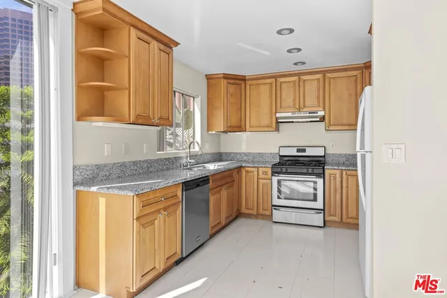 a kitchen with granite countertop a sink and a stove top oven