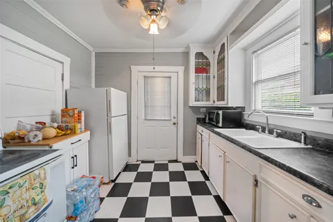 a kitchen with a sink a refrigerator and cabinets
