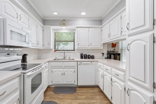 a kitchen with white cabinets and white appliances