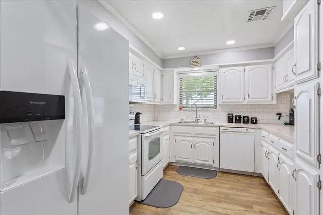 a kitchen with white cabinets and white appliances