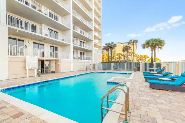 a view of swimming pool with outdoor seating and city view
