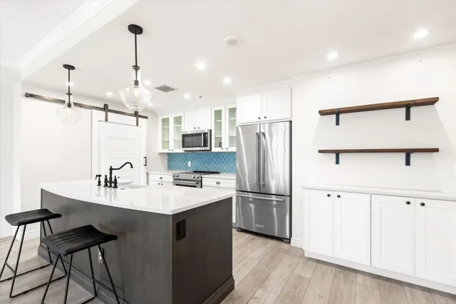 a kitchen with a refrigerator a sink and chairs