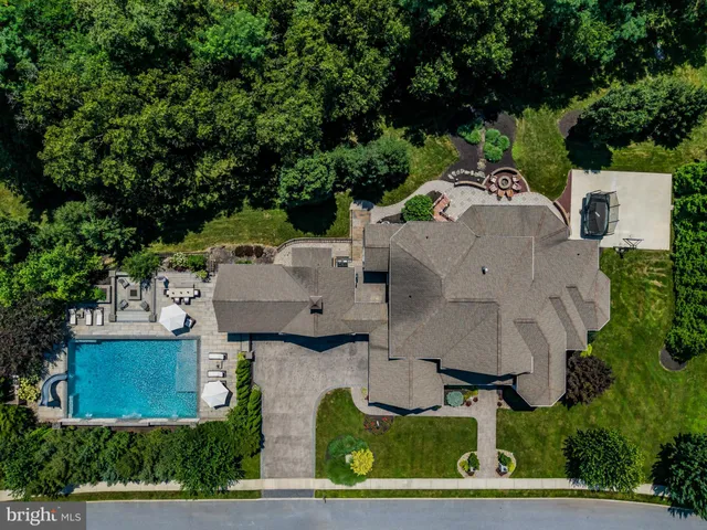 an aerial view of a house with garden space and trees all around