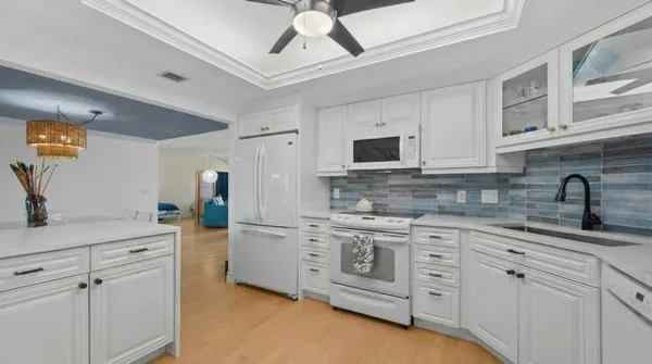 a kitchen with white cabinets stainless steel appliances and sink