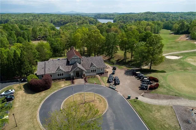 an aerial view of a residential houses with outdoor space and trees