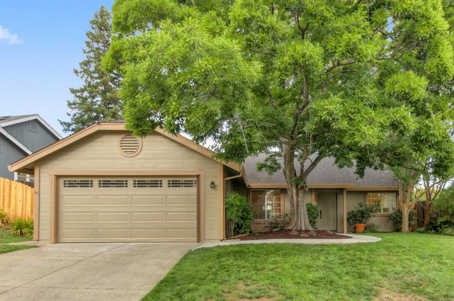 a front view of a house with a yard and trees