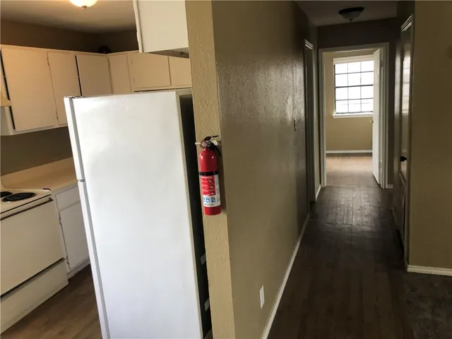 a white refrigerator freezer and a stove sitting inside of a kitchen