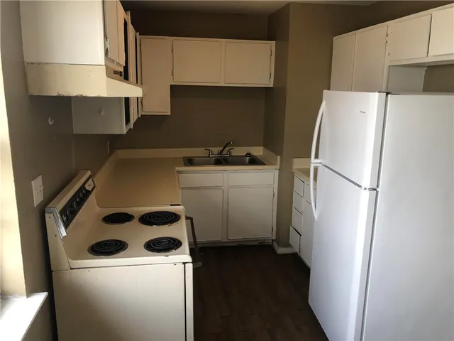 a kitchen with a refrigerator a stove and a sink