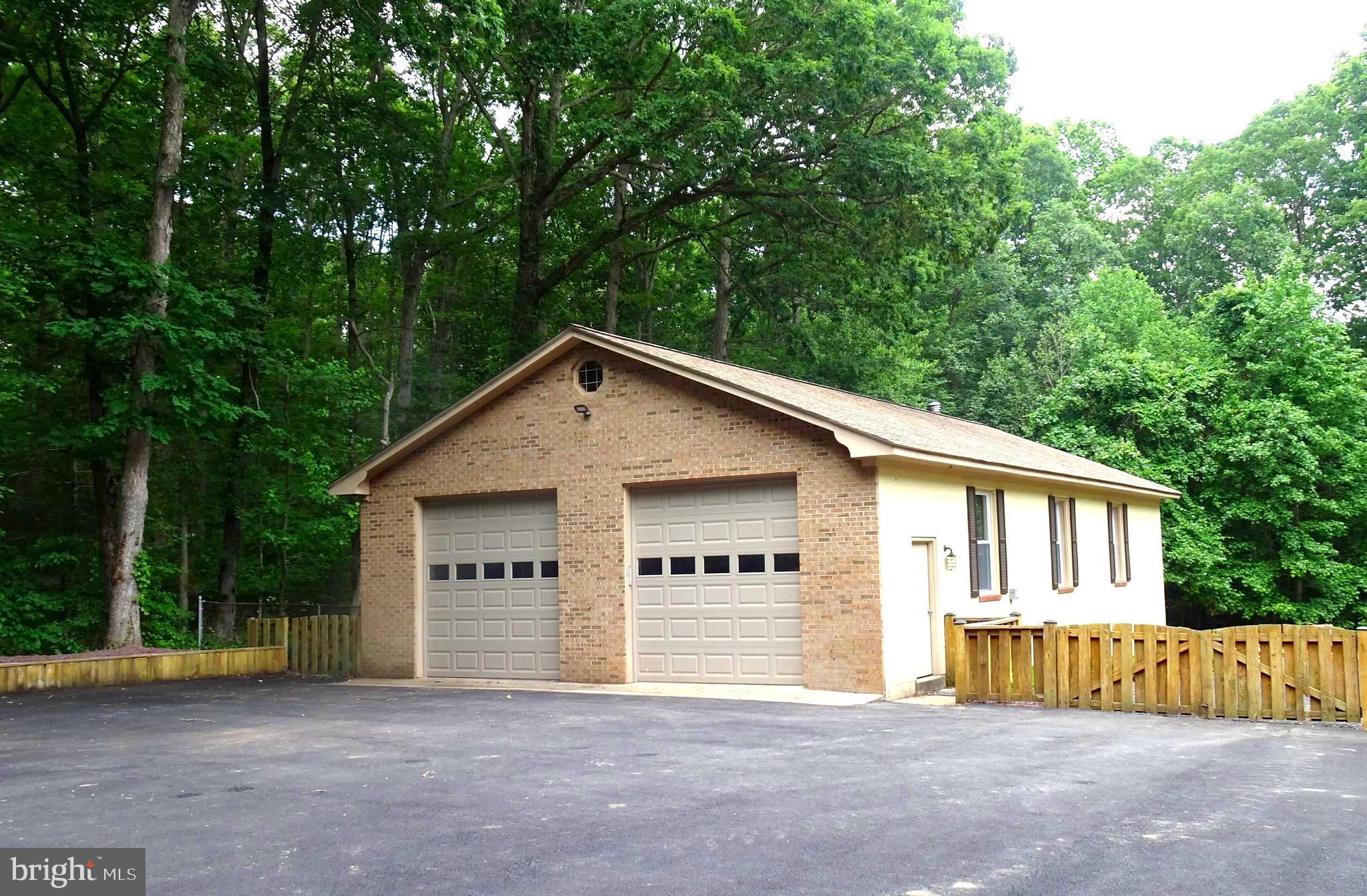 a view of a house with a big yard and large trees