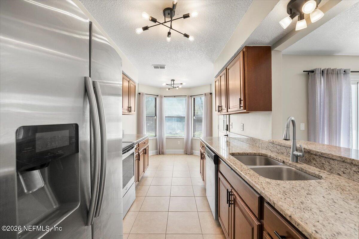 3255 Dowitcher Lane Orange Park, FL 32065 - Photo 10 of 39 a kitchen with stainless steel appliances granite countertop a sink refrigerator and cabinets