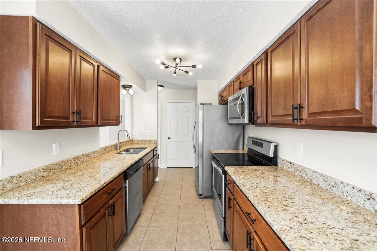 3255 Dowitcher Lane Orange Park, FL 32065 - Photo 8 of 39 a kitchen with granite countertop stainless steel appliances and wooden cabinets