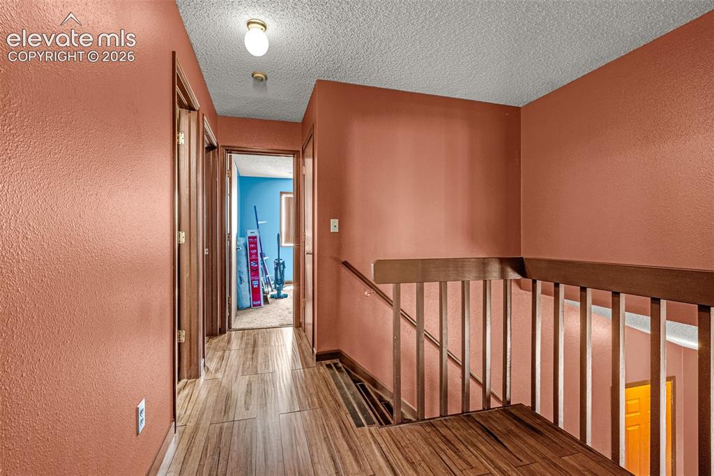 613 Wheat Field Road Fountain, CO 80817 - Photo 9 of 32 a view of a hallway with wooden floor and staircase
