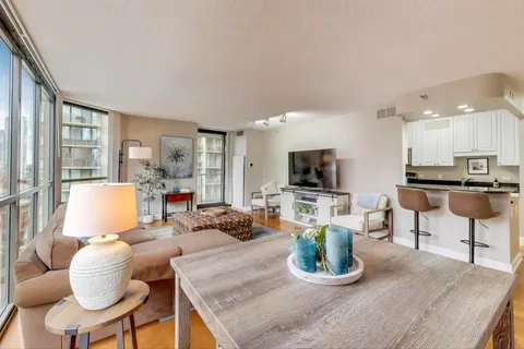 a living room with furniture a flat screen tv and a large window
