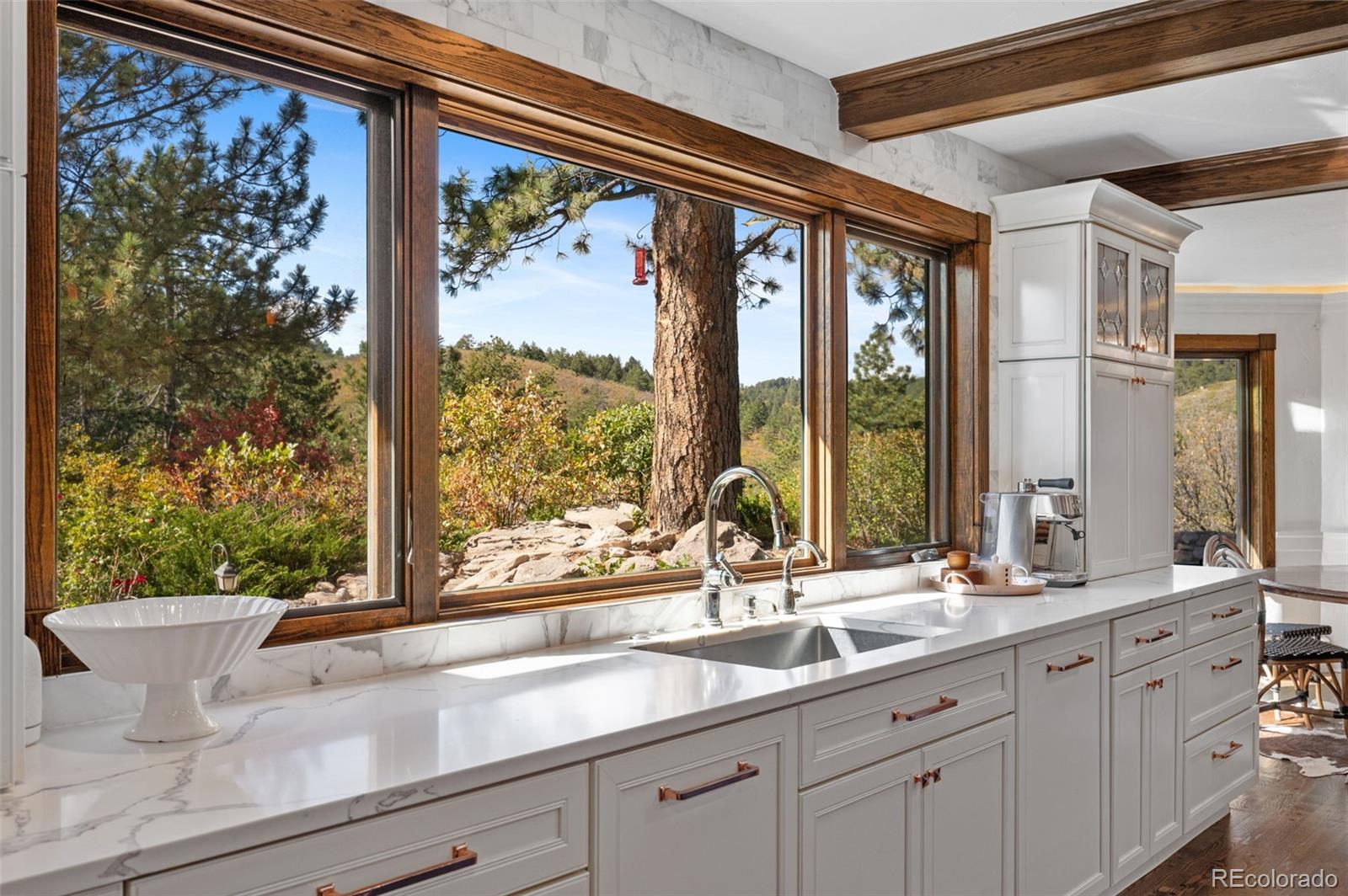 7225 West Box Canyon Road Sedalia, CO 80135 - Photo 18 of 49 a bathroom with a double vanity sink and large windows