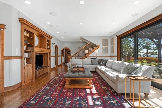 a living room with furniture fireplace and a large window
