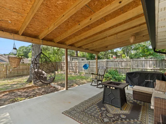 a view of a patio with table and chairs potted plants with wooden fence