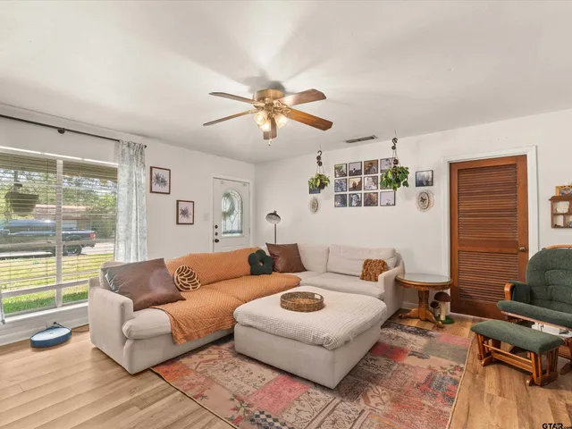 a living room with furniture ceiling fan and a window