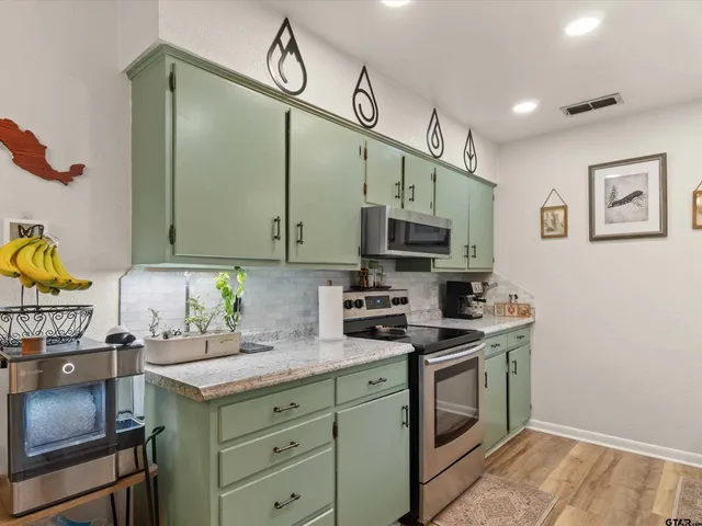 a kitchen with stainless steel appliances granite countertop a sink a stove and cabinets