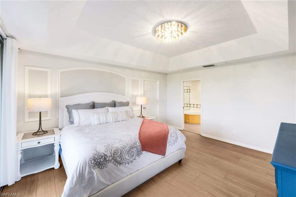 25161 Sandpiper Greens Court, Unit 203 Bonita Springs, FL 34134 - Photo 21 of 36 a bedroom with a bed and wooden floor