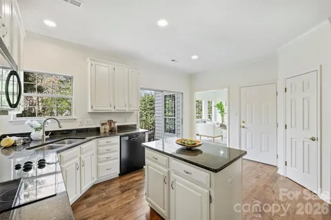 a kitchen with granite countertop a sink stove and cabinets