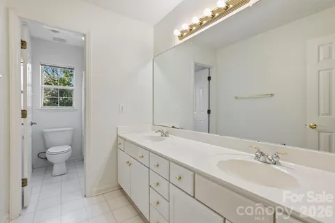 a spacious bathroom with a granite countertop sink mirror and toilet