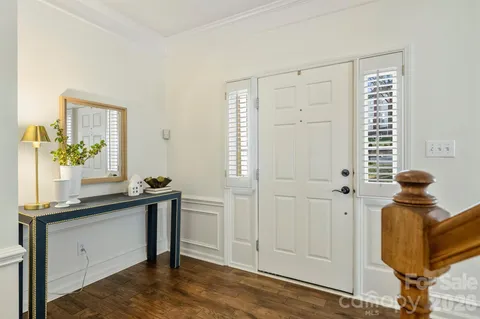 a view of a hallway with entryway and wooden floor
