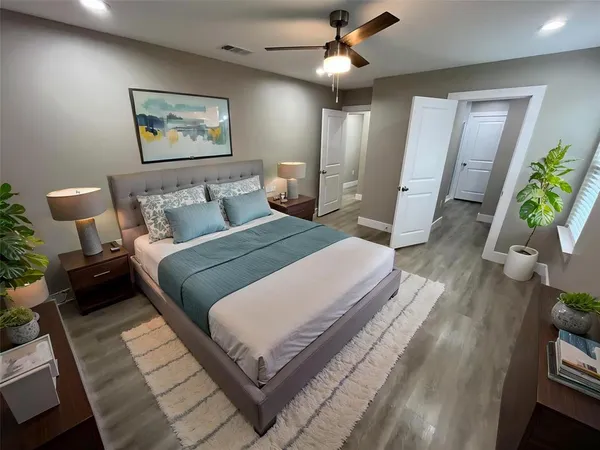 a spacious bedroom with a bed and a chandelier