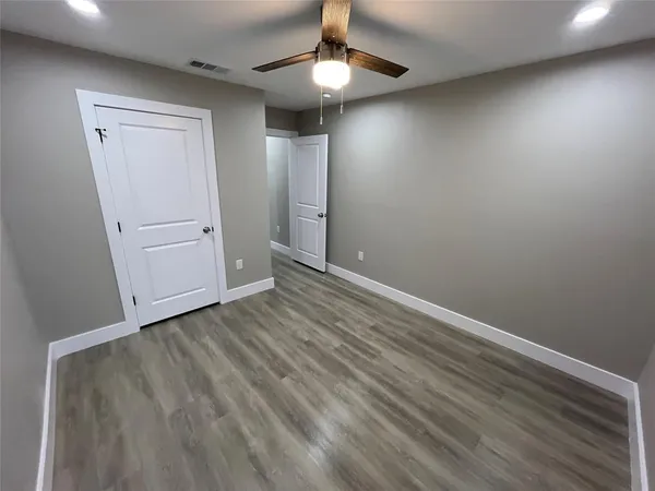 a view of an empty room and chandelier fan