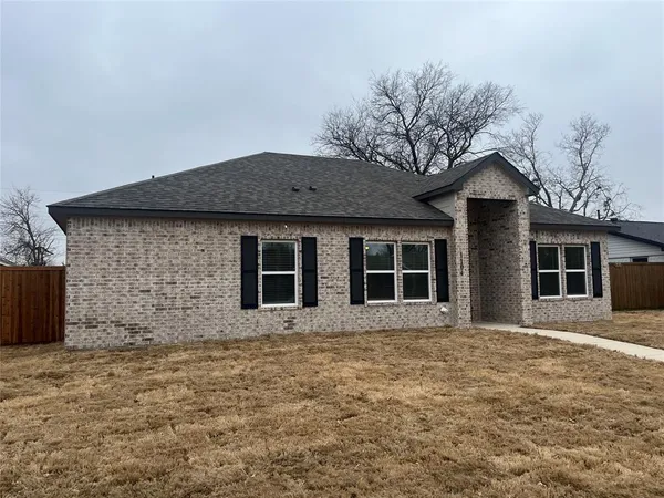 a front view of a house with yard and trees