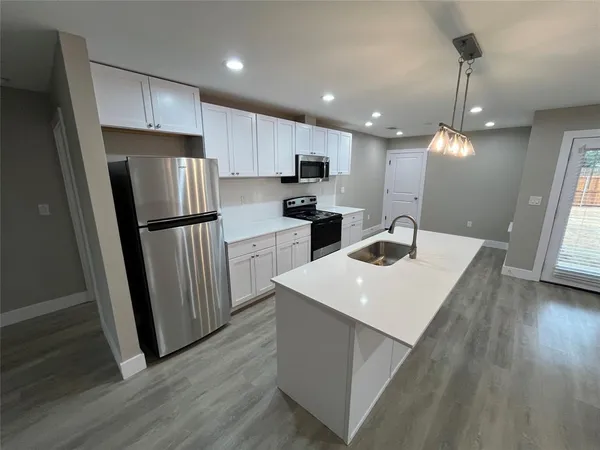 a kitchen with refrigerator cabinets and wooden floor