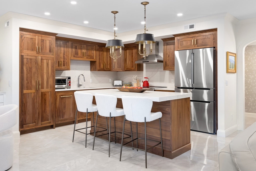 75 Grove Street, Unit 132 Wellesley, MA 02482 - Photo 2 of 20 a kitchen with stainless steel appliances granite countertop a sink refrigerator and microwave
