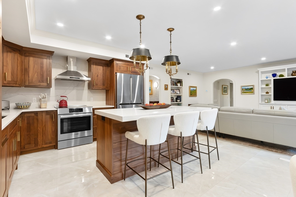 75 Grove Street, Unit 132 Wellesley, MA 02482 - Photo 3 of 20 a kitchen with stainless steel appliances kitchen island granite countertop a sink and a refrigerator