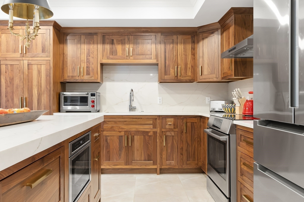 75 Grove Street, Unit 132 Wellesley, MA 02482 - Photo 4 of 20 a kitchen with stainless steel appliances granite countertop a sink stove and microwave