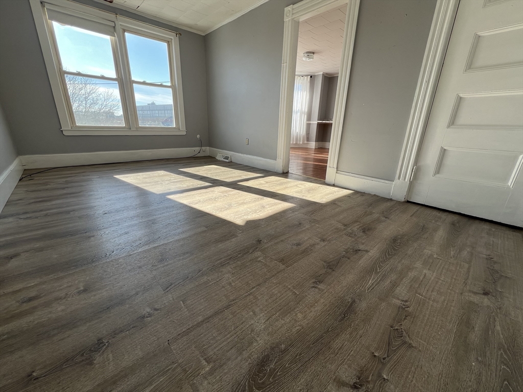 34 Chestnut Street, Unit 3 Wakefield, MA 01880 - Photo 1 of 7 an empty room with wooden floor and windows